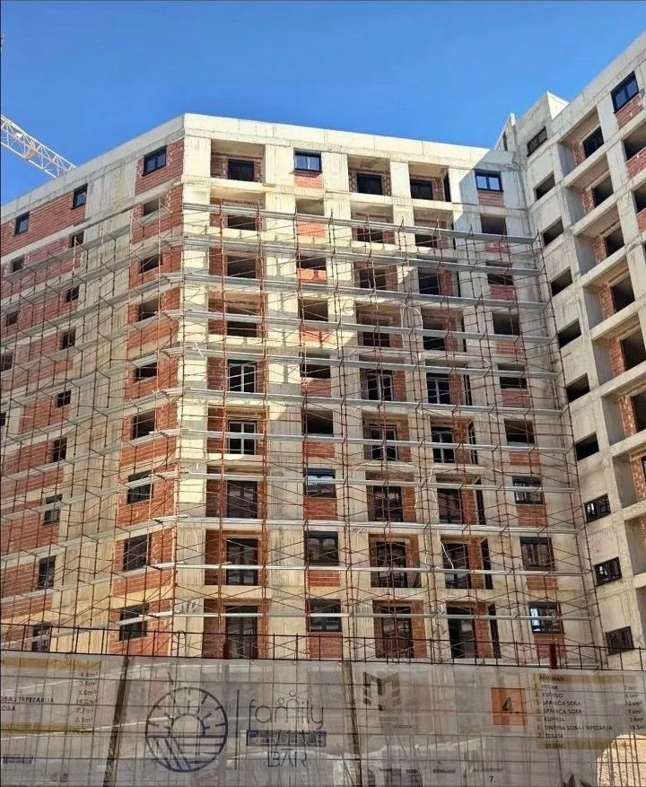 Residential building under construction with scaffolding on the facade.
