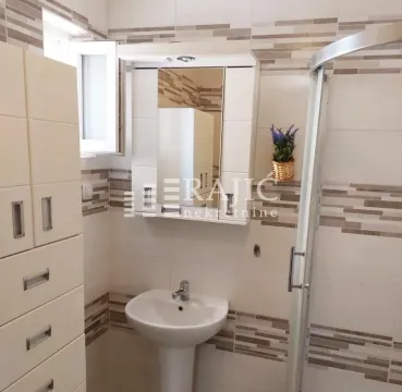 Small bathroom with a washbasin, shower cabin, and mirrored cabinet. - image 9