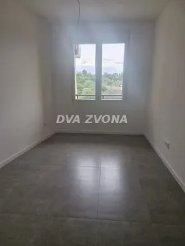 Prazna soba sa sivim pločicama na podu i prozorom. - image 7