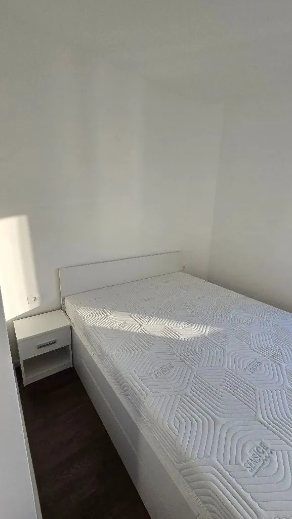 Bright bedroom with a double bed and a nightstand.