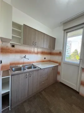 Smaller kitchen with wooden cabinets and access to the terrace. - image 5