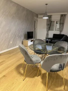 Bright living room featuring a glass dining table and grey chairs. - image 4