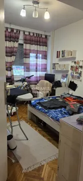 Furnished bedroom with a bed, desk, and ironing board. - image 5