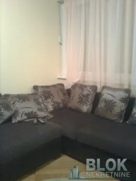 Corner sofa in the living room with cushions and a window in the background. - image 7