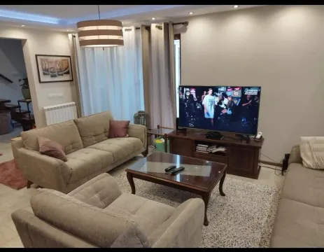 Prostrana dnevna soba sa garniturom za sedenje, stočićem i televizorom. - image 5