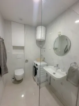 Svijetlo i moderno kupatilo sa veš mašinom i staklenom pregradom. - image 2