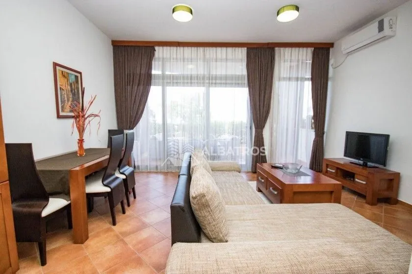 Living room with a sofa set, dining table and access to the terrace.