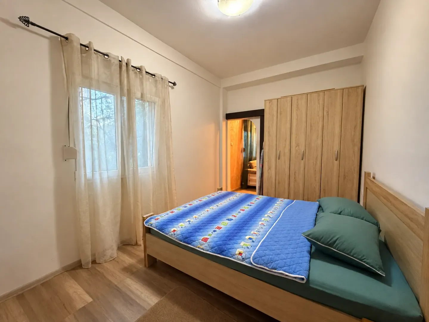 Furnished bedroom with a bed, wardrobe, and window.