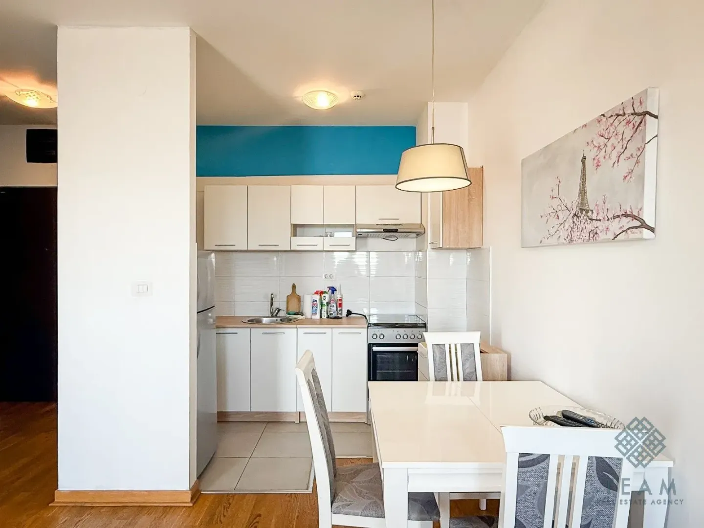 Small kitchen with white cabinets connected to the dining area.