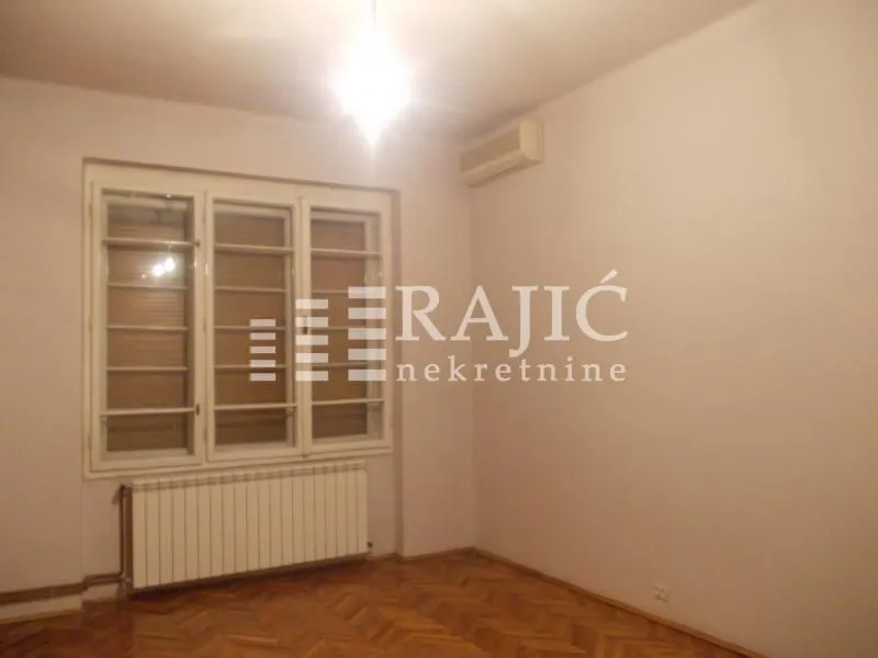 Empty room with parquet flooring, a window, and an air conditioning unit.