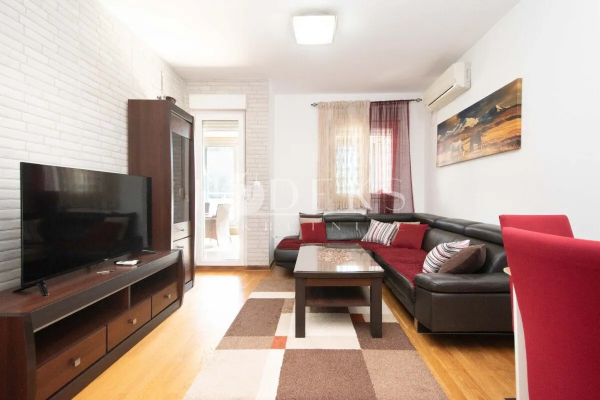 Living room with a sectional sofa, TV, and dining table.