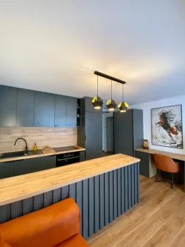 Modern kitchen with a breakfast bar and dining area. - image 5