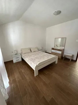Bright bedroom with a double bed, bedside tables, and a dresser with a mirror. - image 5