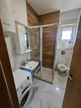 Modernly equipped bathroom with a shower cabin and a washing machine. - image 6