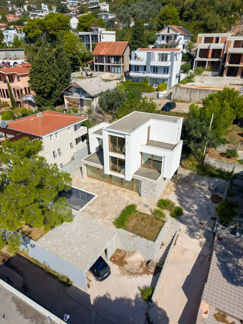 Pogled iz vazduha na modernu kuću sa dvorištem i okruženjem.