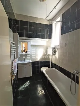 Manje kupatilo sa kadom, umivaonikom i tamnim pločicama. - image 8