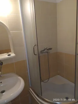 A simple bathroom with a shower cabin and a washbasin. - image 3