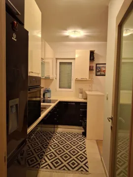 Small kitchen with black and white elements and a window. - image 10