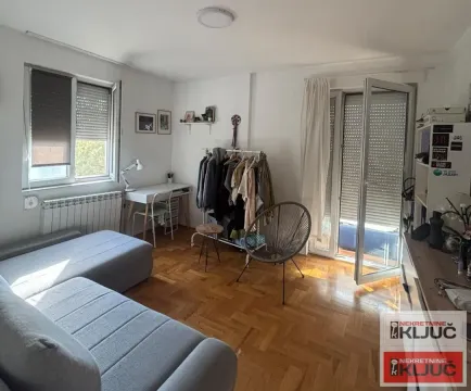 Dnevna soba sa garniturom, radnim stolom i izlazom na terasu. - image 8