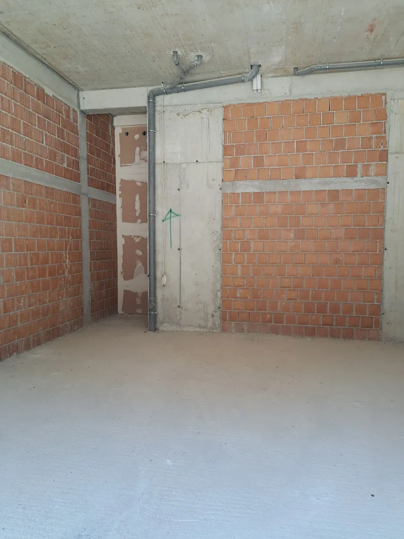 Interior of an unfurnished space in rough construction phase with installations.