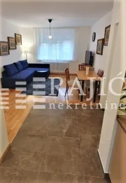 Living room with a sofa and dining area. - image 4