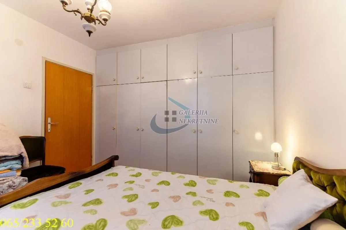 Furnished bedroom with a large built-in wardrobe and a bed.