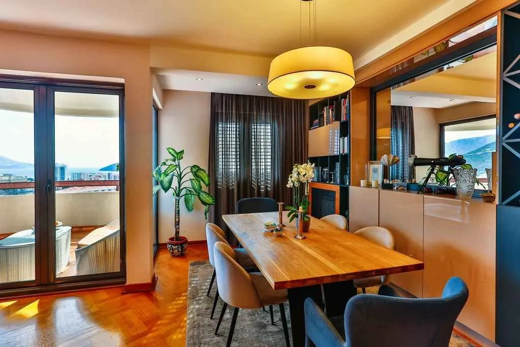 Bright dining area with a wooden table and access to the terrace.