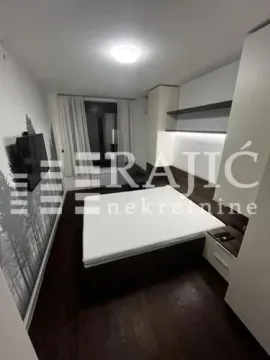 Modern bedroom with a double bed, built-in wardrobes and a wall-mounted TV. - image 11