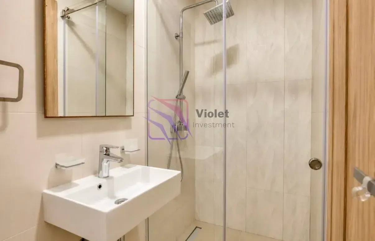 Modernly equipped bathroom with a washbasin and a walk-in shower.
