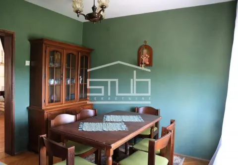 Dining area with a wooden table, chairs, and a cabinet in a room with green walls. - image 15