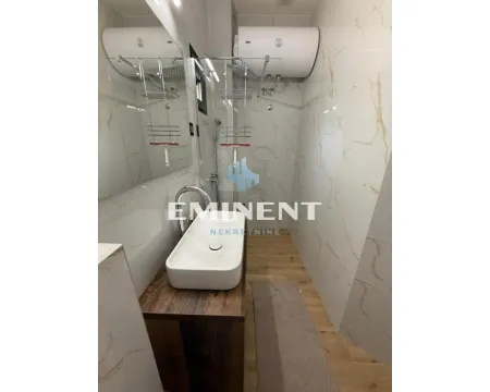 Smaller bathroom with a shower cabin, washbasin, and water heater. - image 14