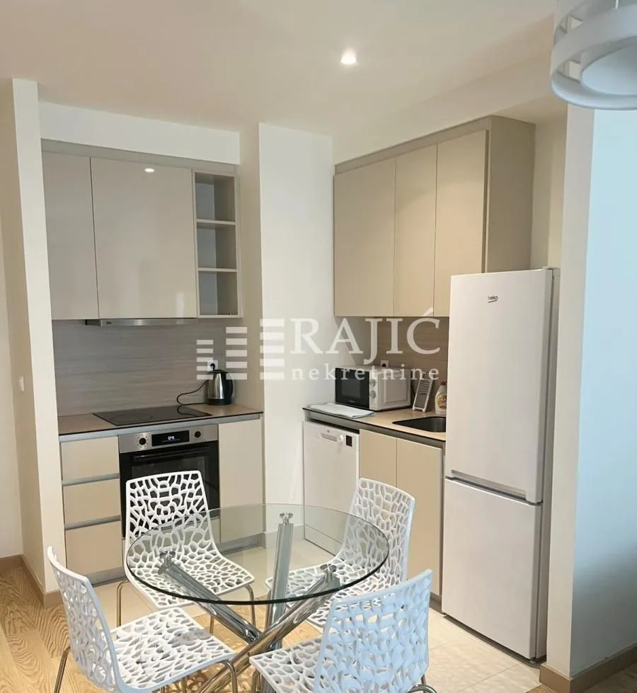 Modern kitchen with dining area and built-in appliances.