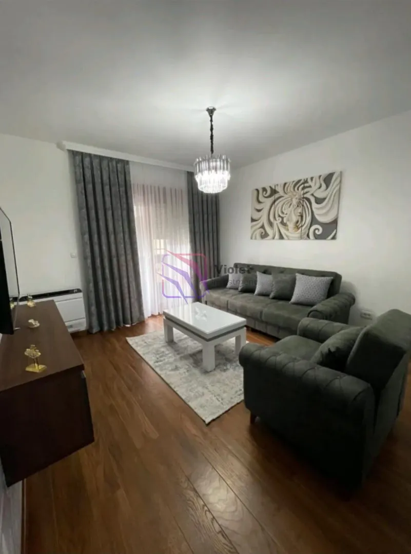Dnevna soba sa garniturom, stočićem i TV komodom.