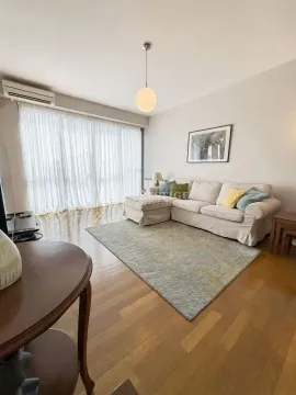 Spacious living room with a sofa and large windows. - image 3