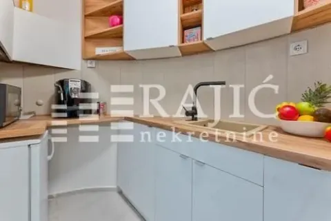Modern kitchen with white cabinets and a wooden countertop. - image 8
