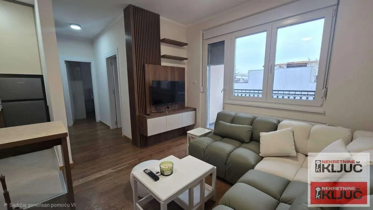 Living room with a sofa, TV, and a large window.