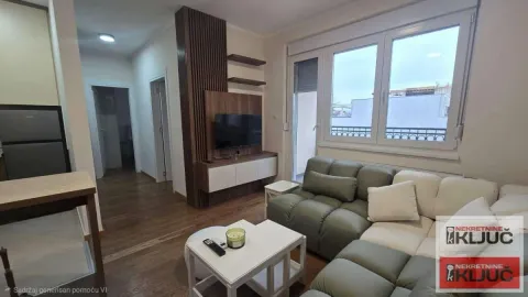 Living room with a sofa, TV, and a large window. - image 2