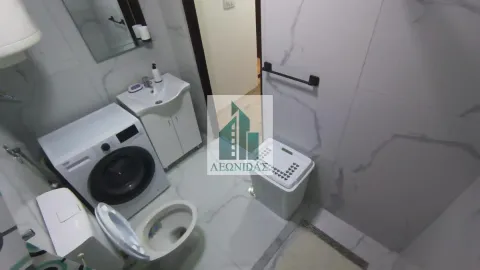 Compact bathroom with a shower cabin, washbasin, and washing machine. - image 7