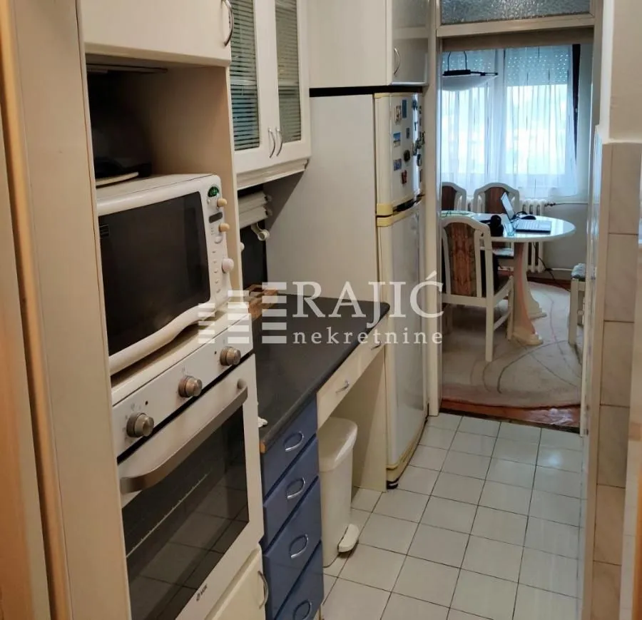 View of a small kitchen with built-in appliances.
