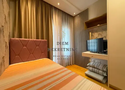 Furnished bedroom with a bed, TV, and built-in wardrobe. - image 14