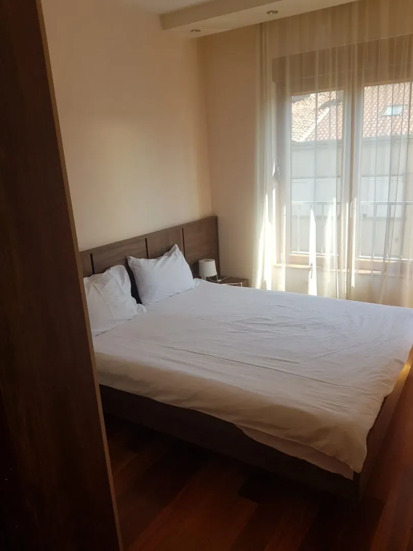 Bright bedroom with a double bed next to the window.