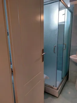 Kupatilo sa tuš kabinom viđeno kroz otvorena vrata. - image 18