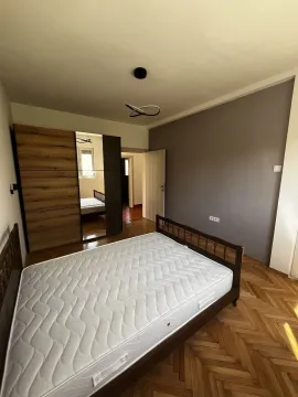 Svijetla spavaća soba sa drvenim krevetom i velikim ormarom sa ogledalom. - image 12