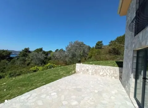 Popločano dvorište ispred kamene kuće sa pogledom na zeleno okruženje. - image 5