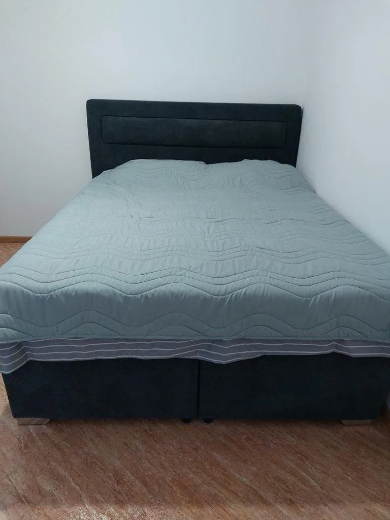 Double bed with bedding in the bedroom.