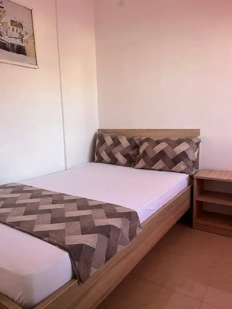 Small bedroom with a bed and a nightstand.