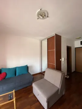 Living room with a sofa, armchair, and built-in wardrobe. - image 2