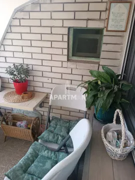 Smaller balcony with chairs, potted plants and brick wall details. - image 2