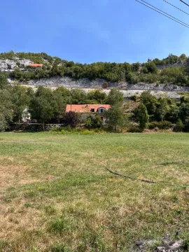 Pogled na kuću sa velikim travnjakom i brdima u pozadini. - image 4