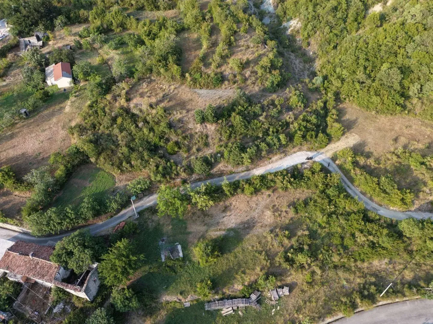 Pogled iz vazduha na zemljište sa zelenilom i pristupnim putem.